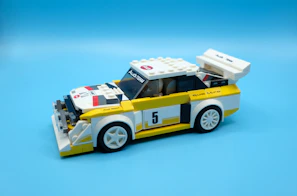 Close-up of a completed Lego race car with shiny wheels, ready to zoom across the floor.