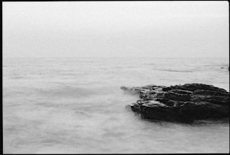 Black and white photo of a calm sea at dawn symbolizing new beginnings and clarity.