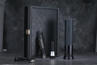 an electronic device sitting next to a leather case