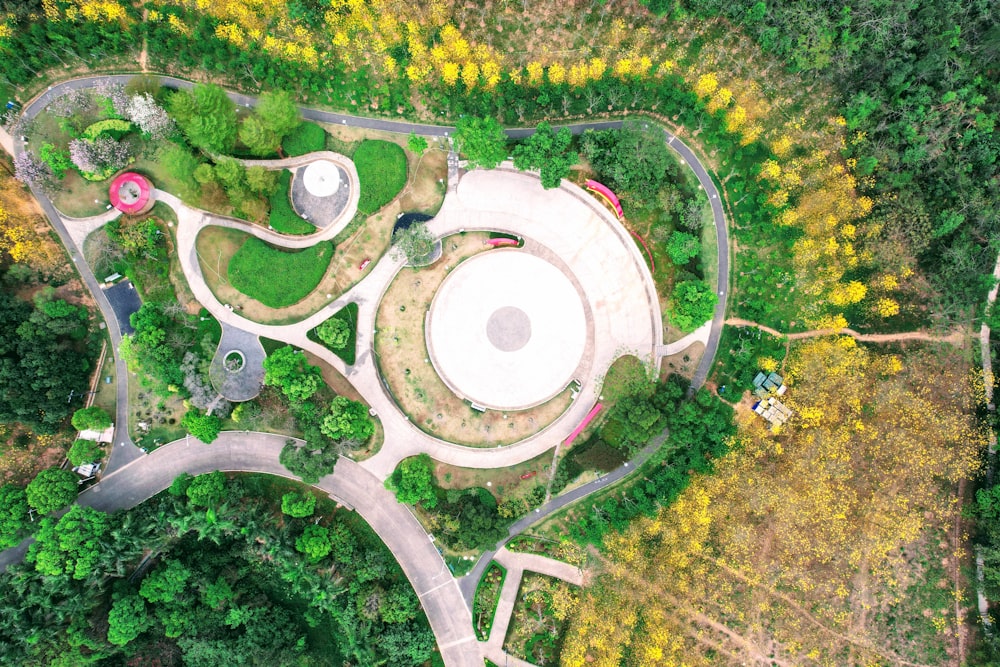 a bird's eye view of a circular building in the middle of a forest
