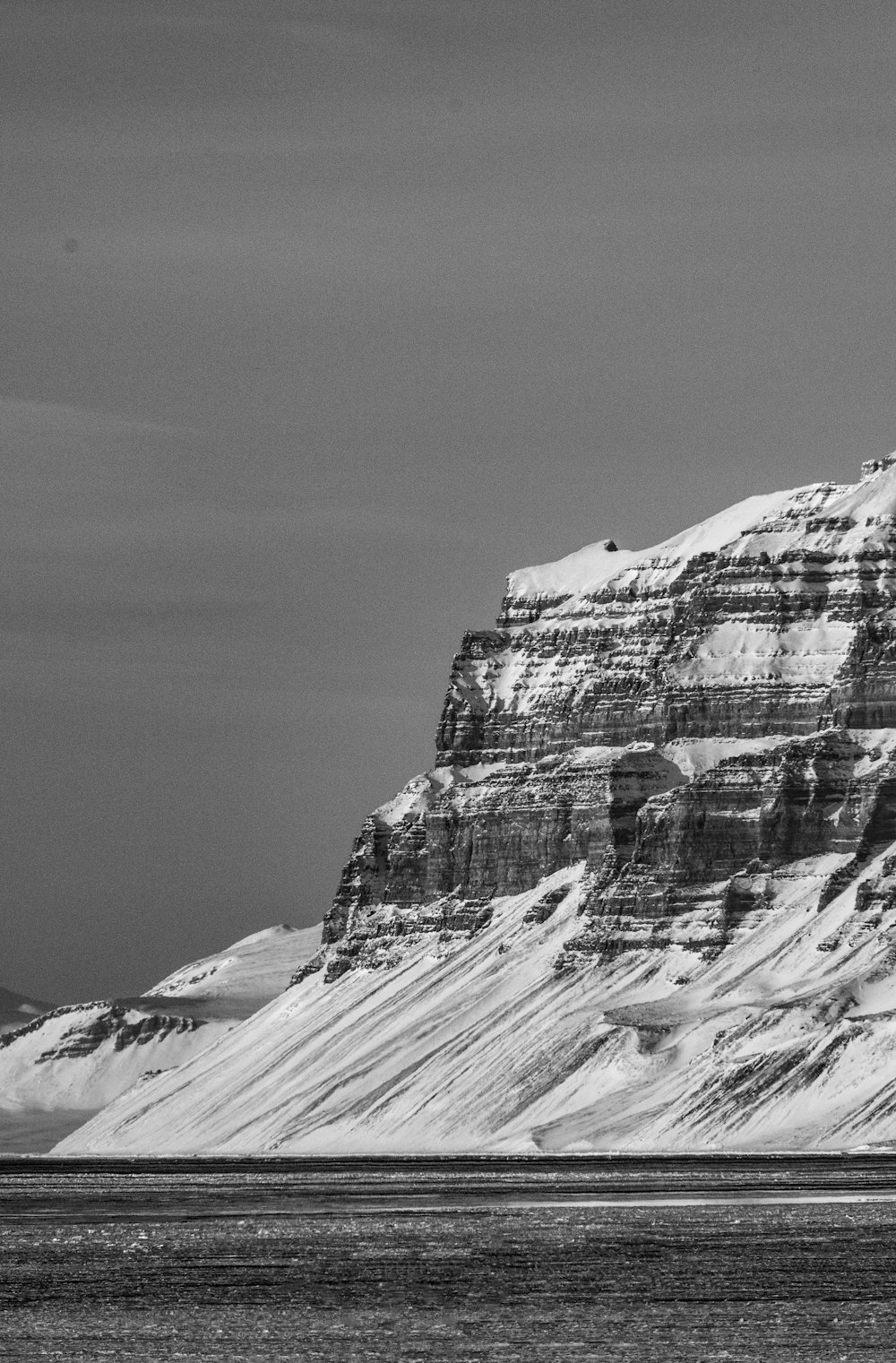 a black and white photo of a snow covered mountain