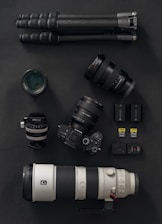 a camera, a lens, and a tripod on a table