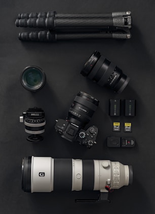 a camera, a lens, and a tripod on a table