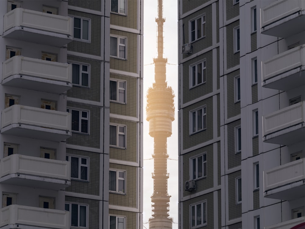 a tall building towering over a city next to tall buildings