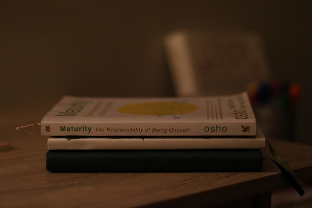 a stack of books sitting on top of a wooden table