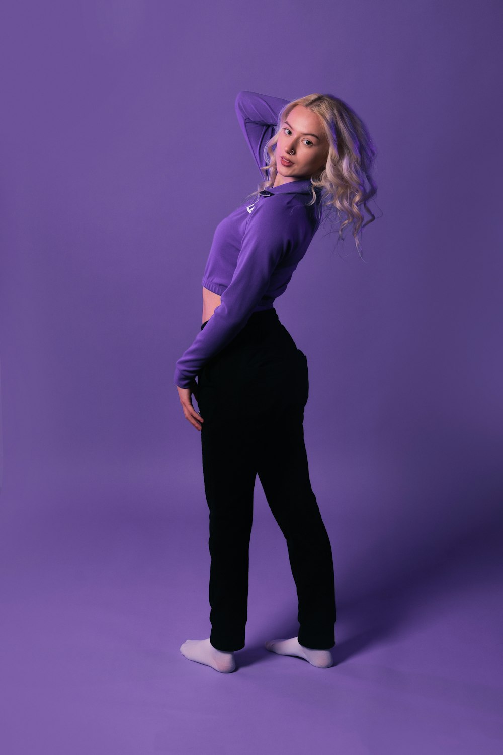 a woman in a purple shirt and black pants