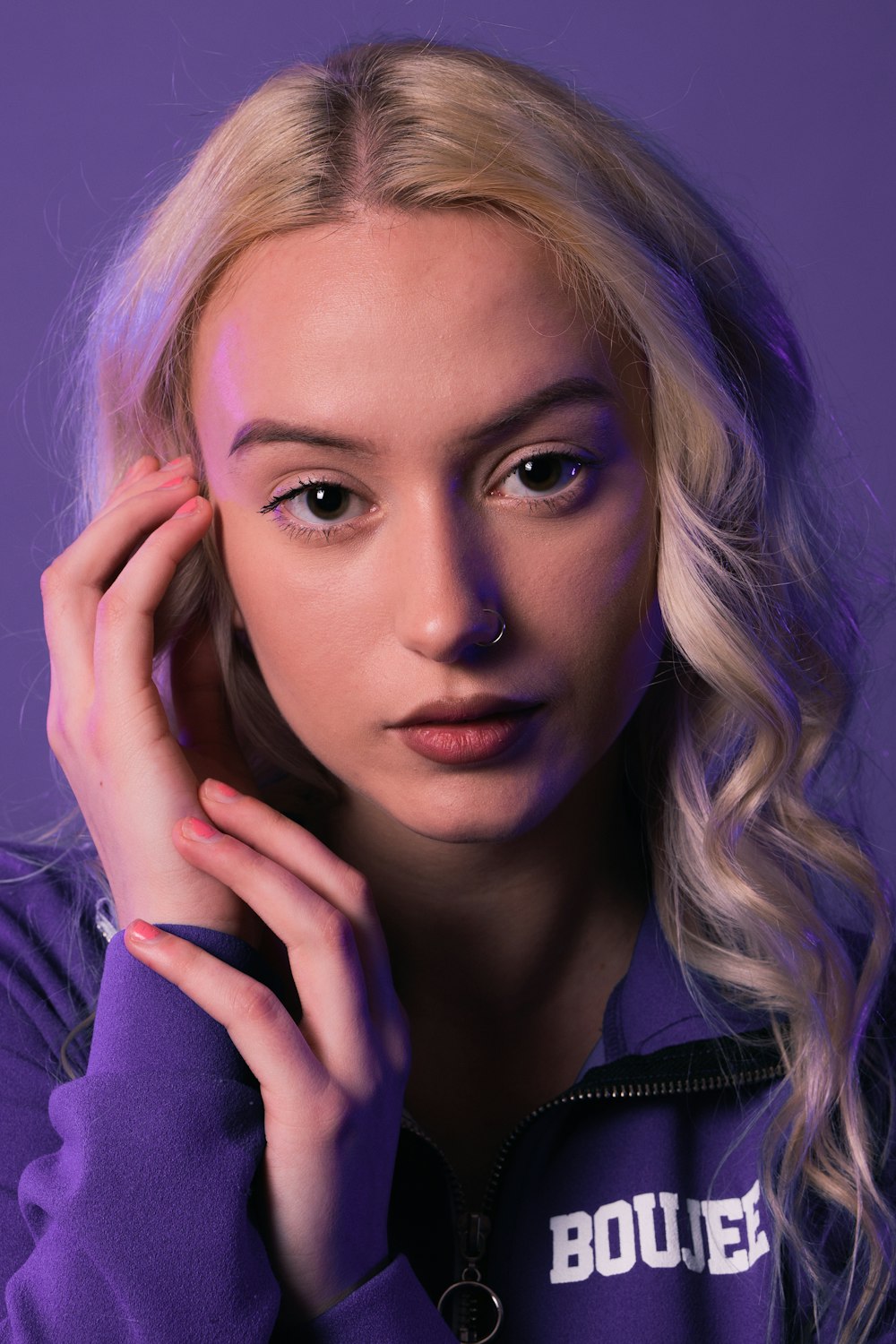 a woman with blonde hair wearing a purple sweatshirt