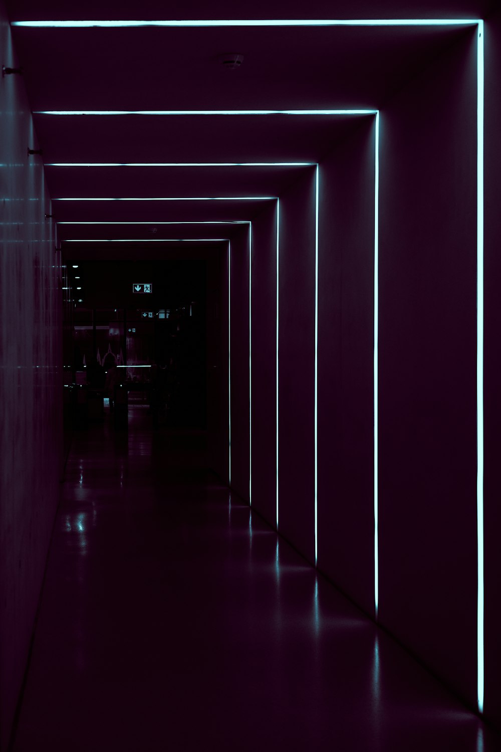 a long hallway with neon lights on the walls