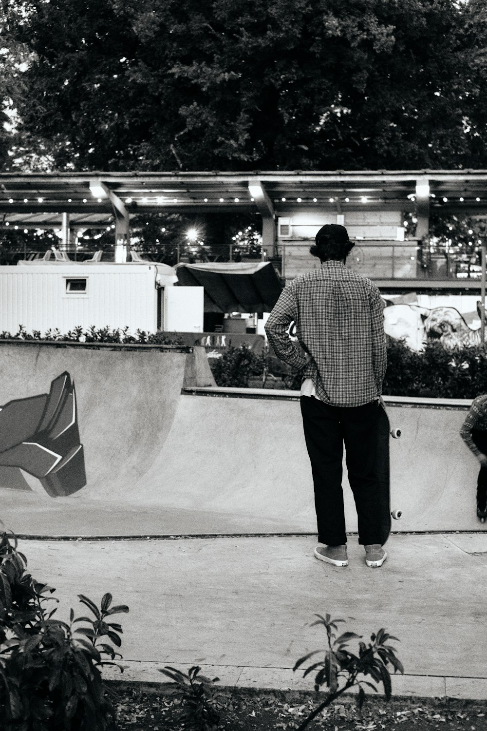 Une photo en noir et blanc d’un homme dans un parc de planche à roulettes