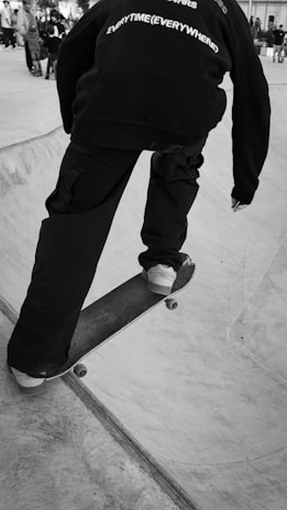 A dynamic shot of a skateboarder wearing a hoodie and funky shorts.