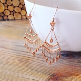 A pair of elegant chandelier earrings shimmering under warm lighting.
