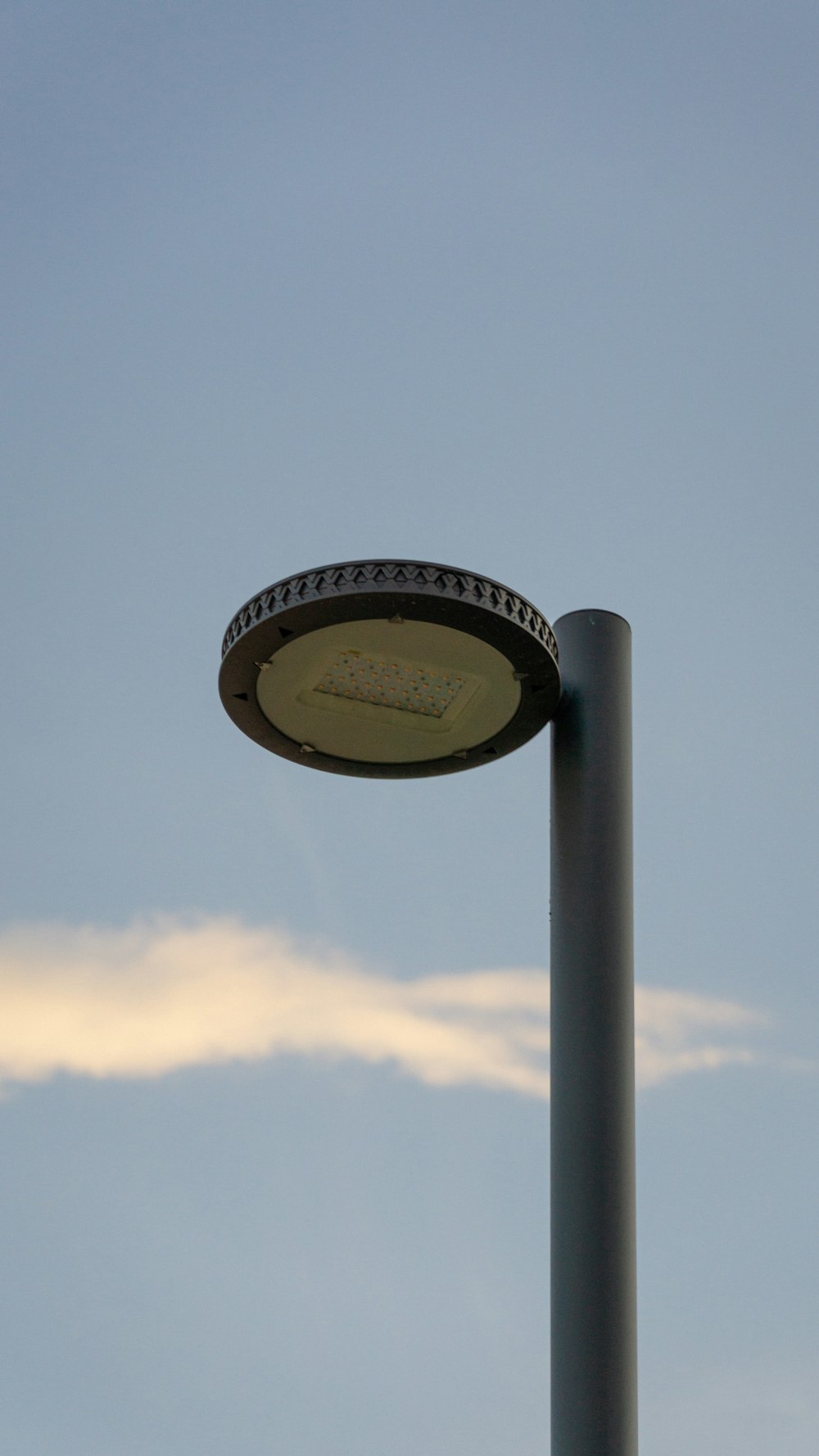 a street light with a cloud in the sky