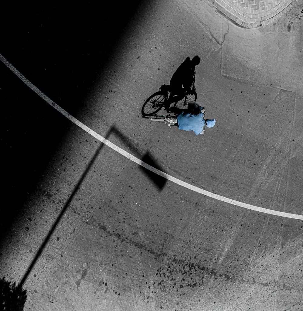 a man riding a bike down a street next to a blue fire hydrant