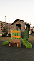 a children's play structure with a green slide