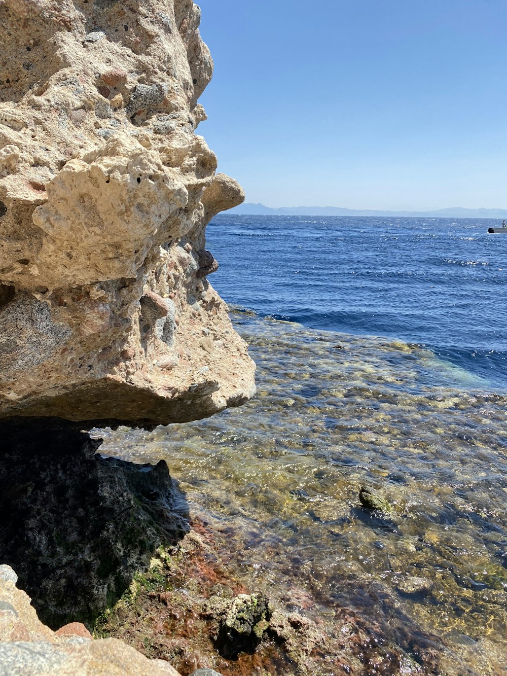 a large rock sticking out of the water