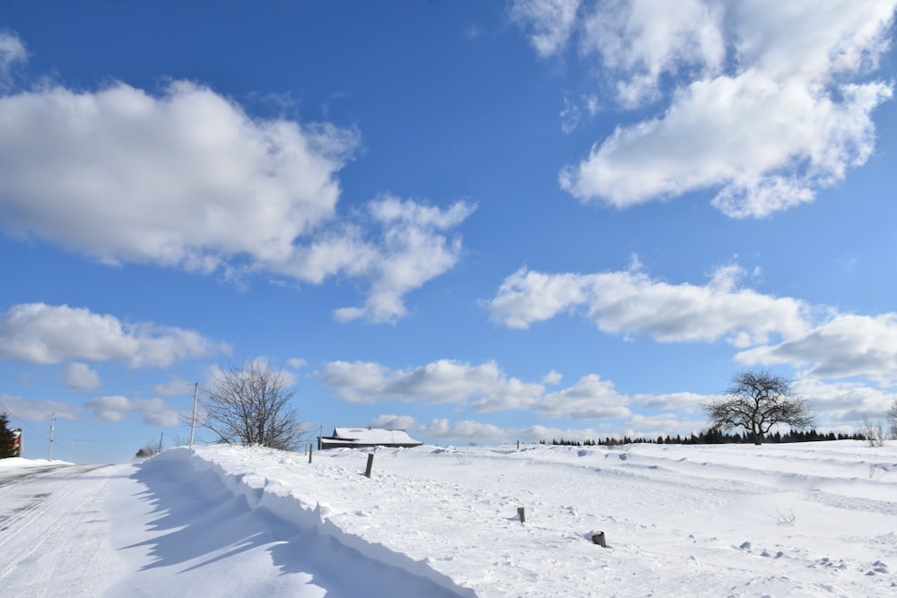 Un camino cubierto de nieve bajo un cielo azul nublado