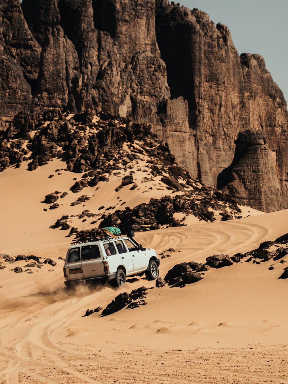 산을 배경으로 사막을 운전하는 자동차
