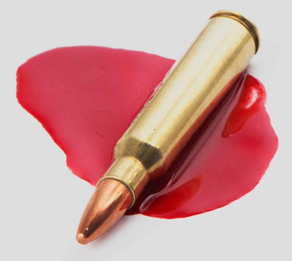 a red lipstick with a bullet sticking out of it