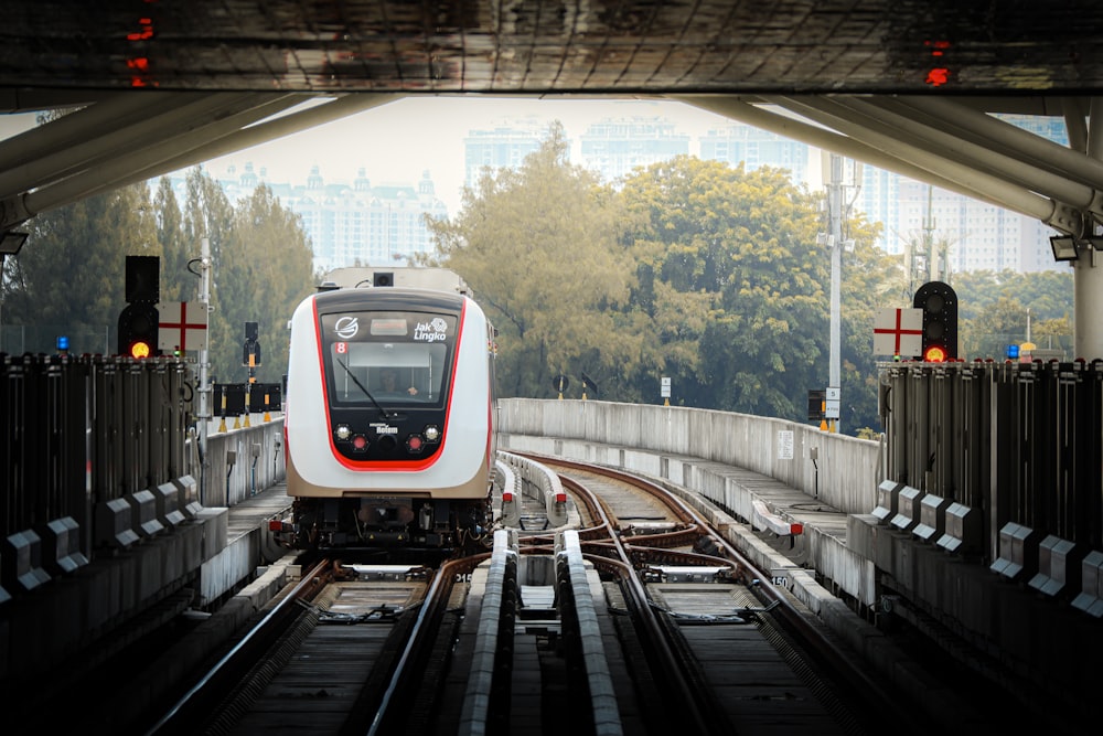 a red and white train traveling down train tracks