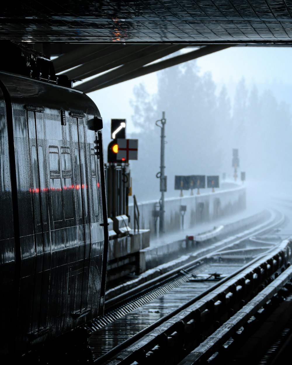 a train traveling down train tracks next to a forest