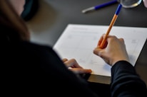 Close-up of hands writing a business strategy plan on paper.
