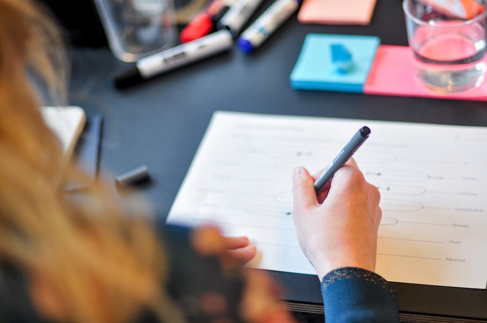 a person writing on a piece of paper