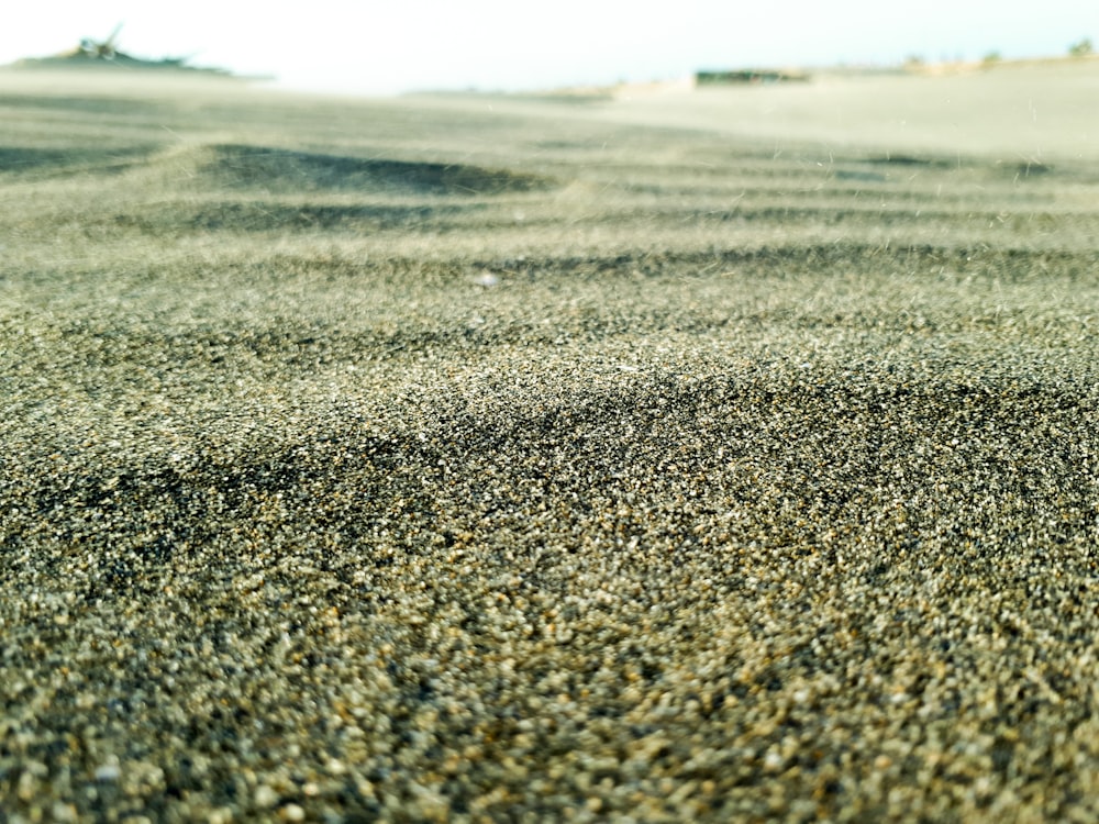 a close up of a sand dune with a blue sky in the background