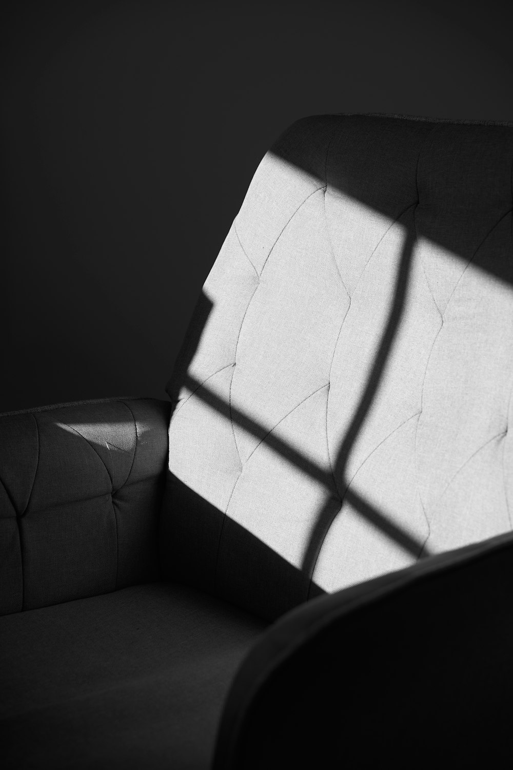 a black and white photo of a chair and a window