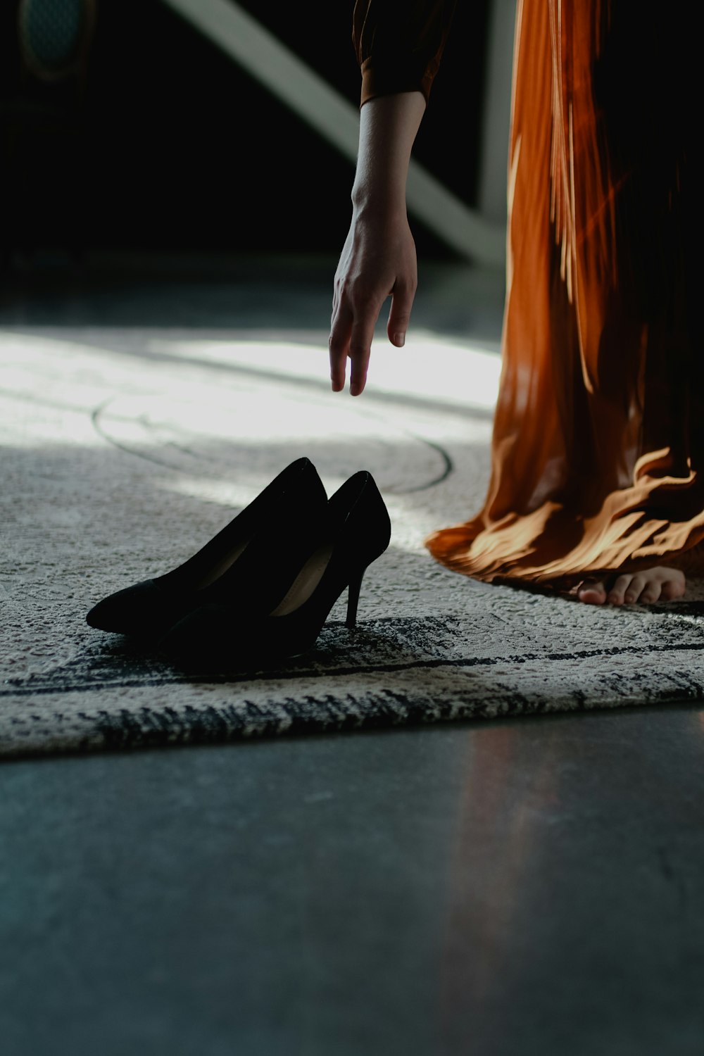 a woman is reaching for a high heeled shoe
