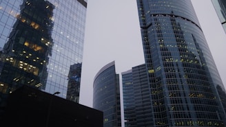 Commercial office towers reflecting sunlight with busy urban surroundings.