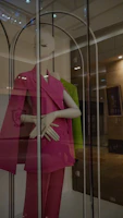 Soft pink women's suit shirt displayed on a mannequin with gentle natural lighting