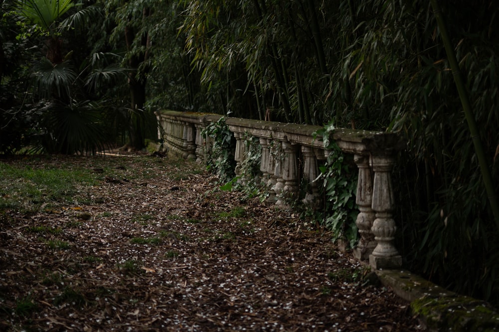 a row of stone pillars sitting next to a lush green forest