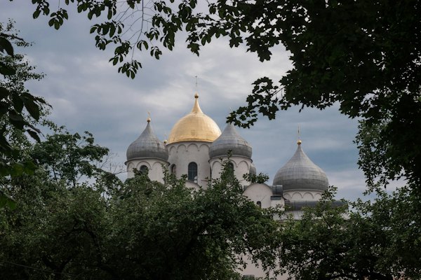 The silver and gold domes of St Sophia through the trees — Veliky Novgorod, Russia