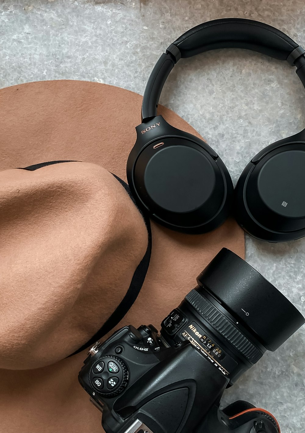 a hat, camera, headphones and a hat on a table