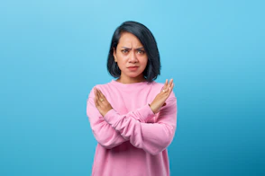 a woman in a pink sweater is holding her hands together