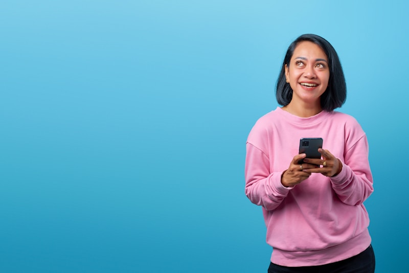 stylish woman in pink shirt with mobile device