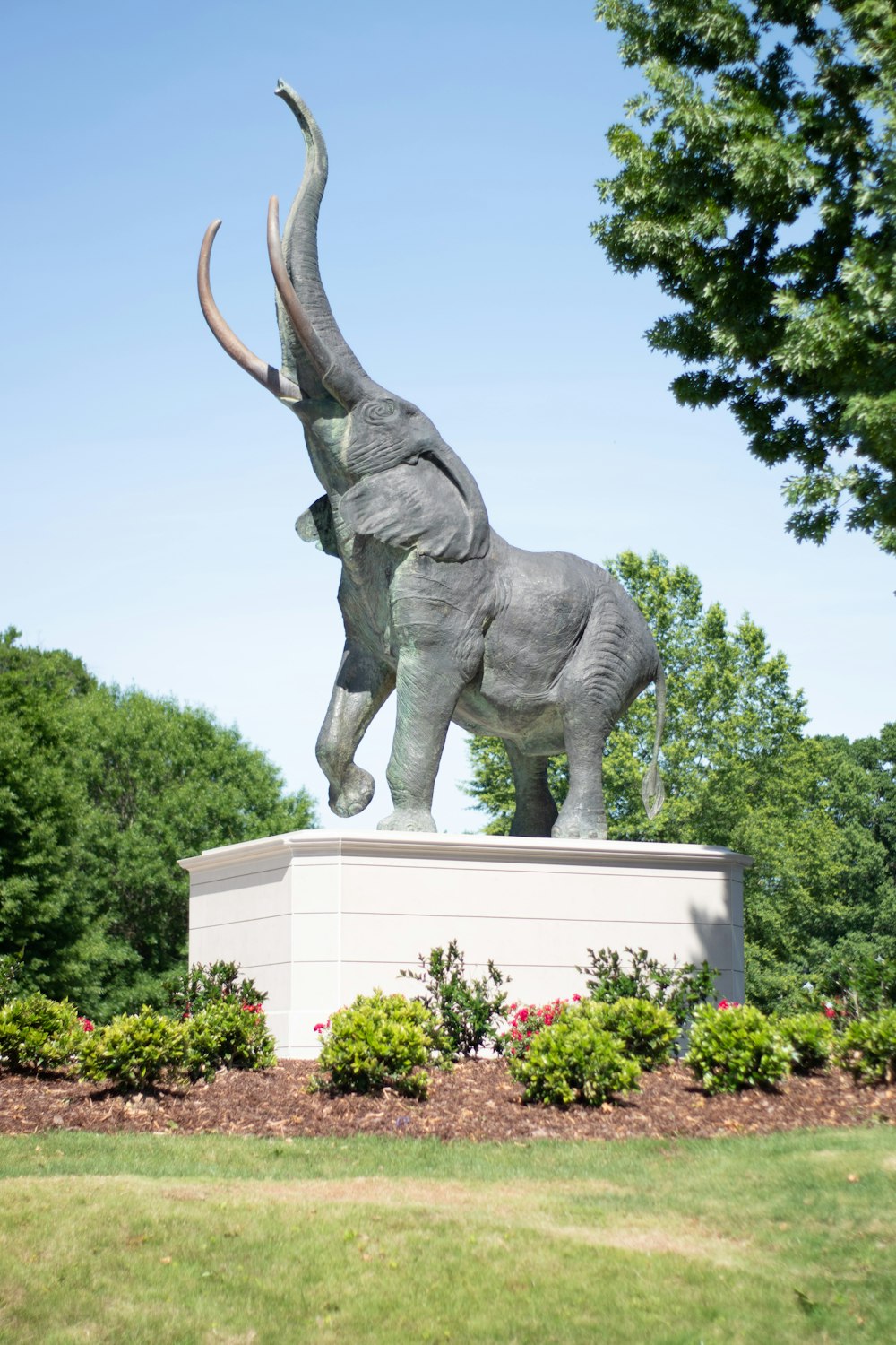 a statue of an elephant with its trunk in the air