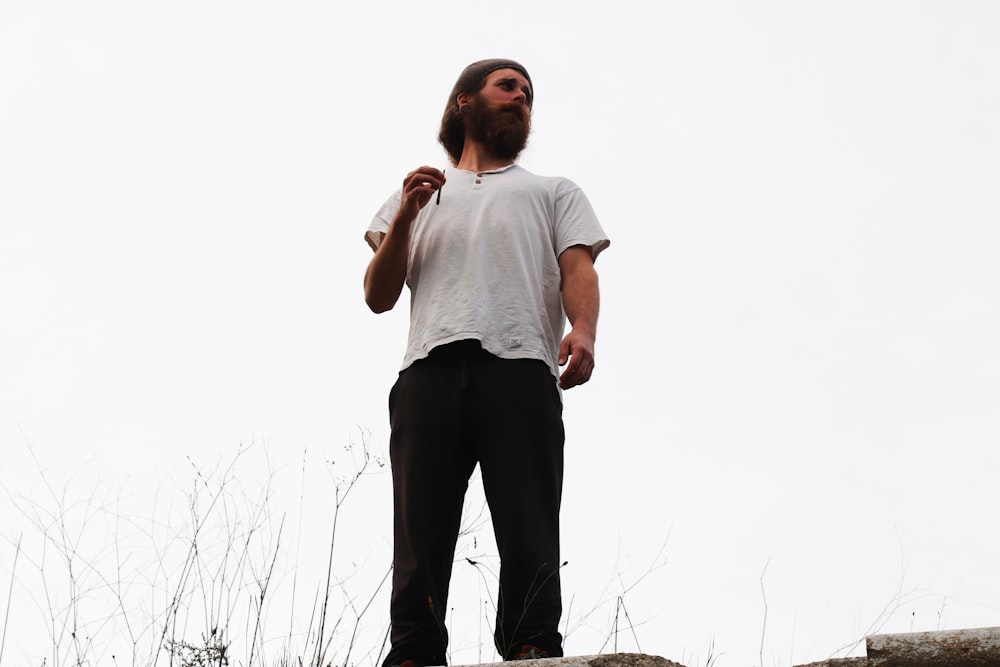 a man with a long beard standing on a rock