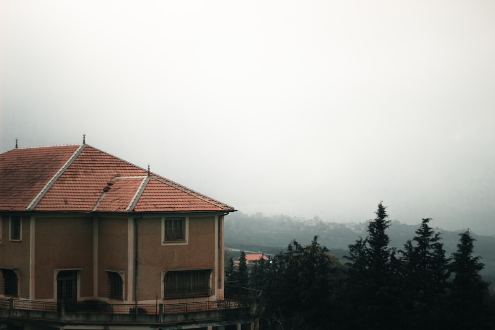 a house on a hill with trees in the foreground