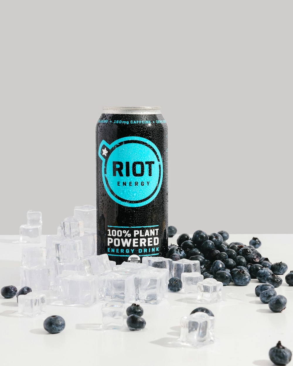 a can of riot on a table with ice cubes