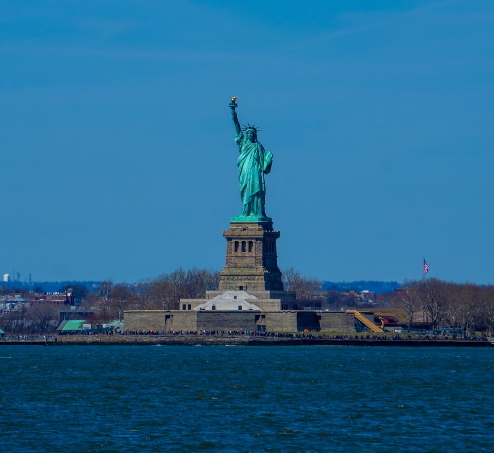 the statue of liberty stands in the middle of the water