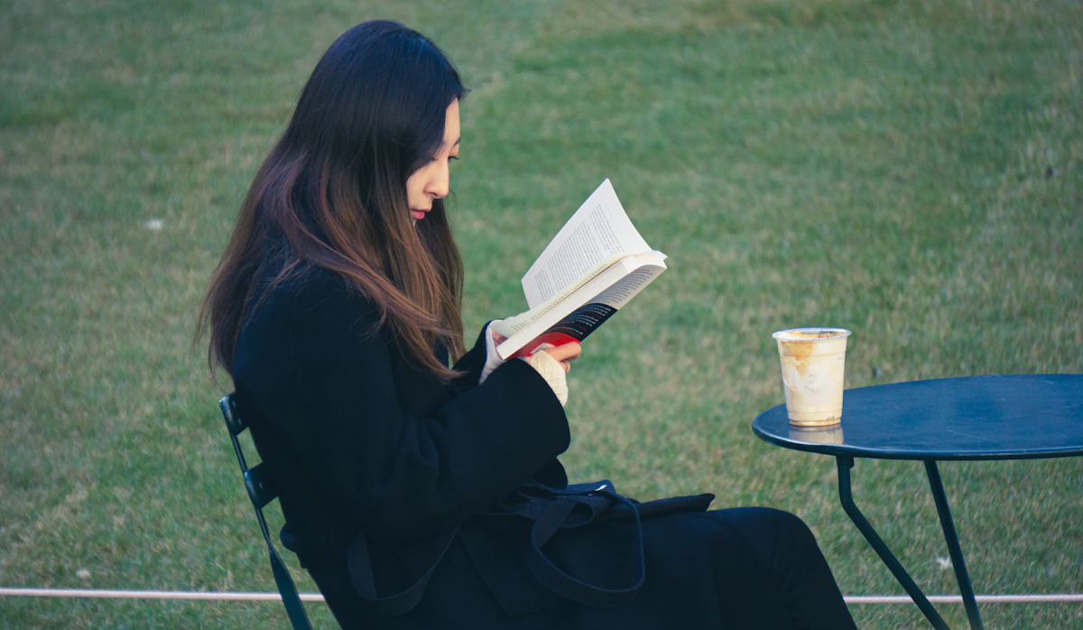 A woman sitting comfortably in a chair reading a book