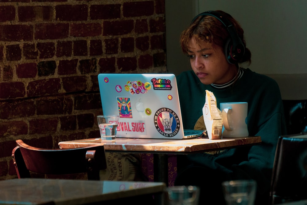 a woman sitting in front of a laptop computer