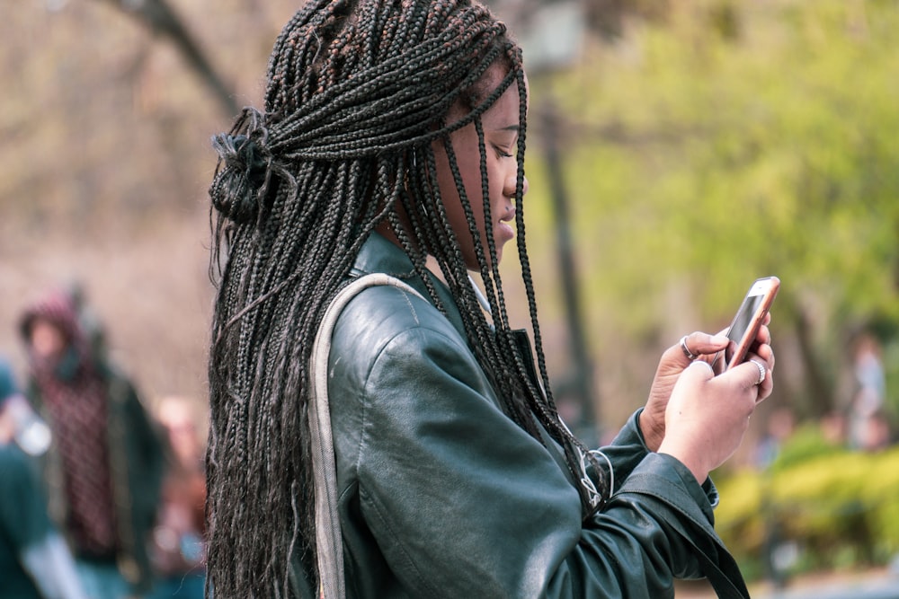 a woman with dreadlocks looking at her cell phone