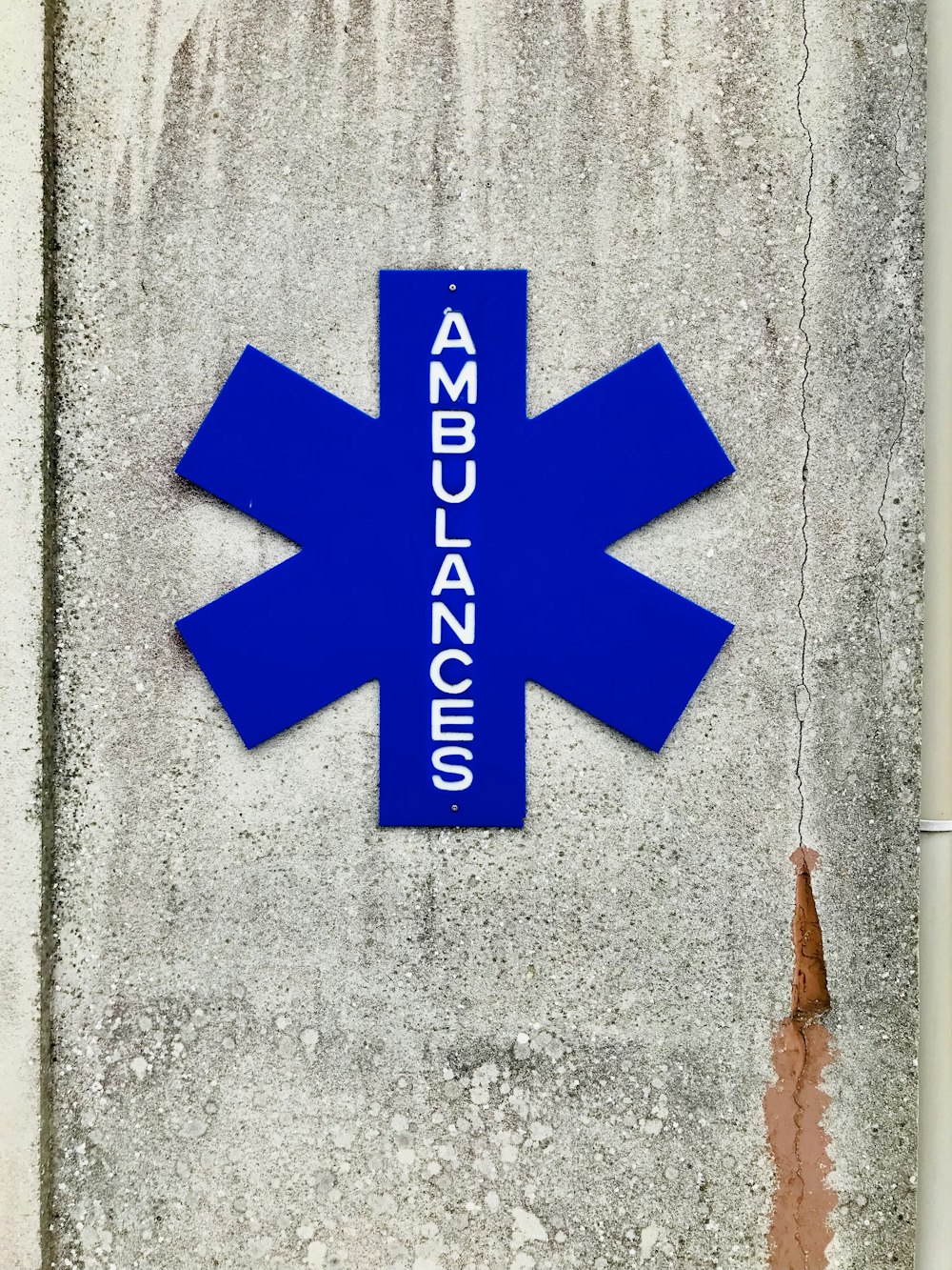 a blue emergency sign mounted to the side of a building