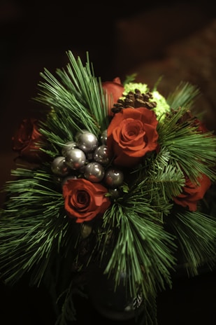 An elegant bouquet with bold reds and greens, tied with a natural twine ribbon, ready for gifting.