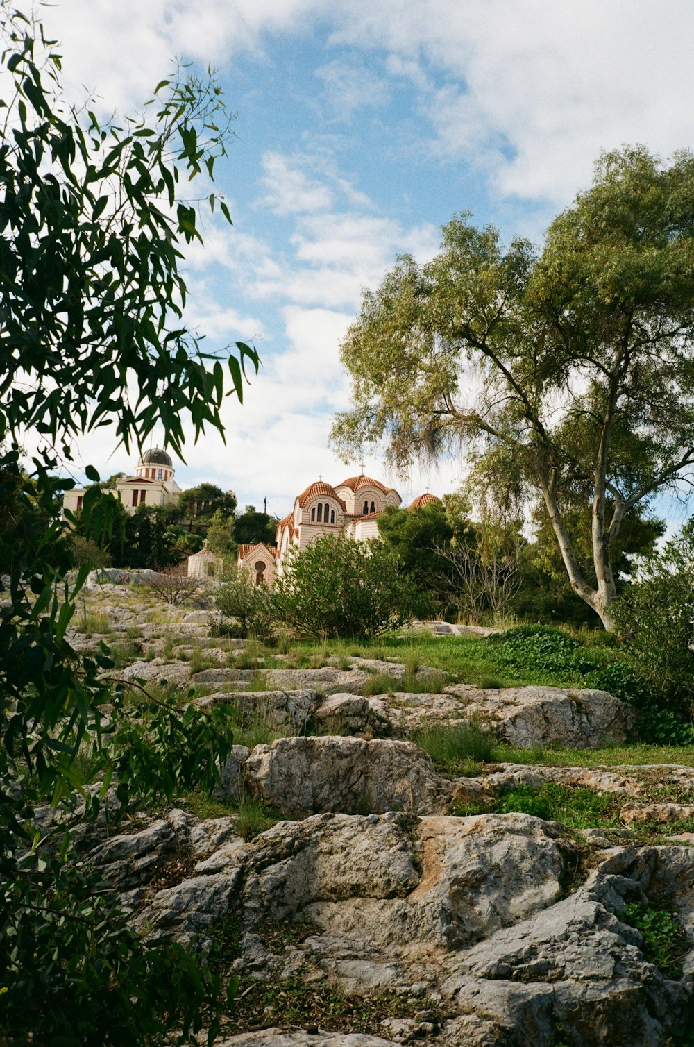 a large house sitting on top of a lush green hillside