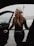 A happy customer standing next to her car with new winter tires.