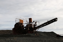 an old rusty machine sitting on top of a pile of dirt