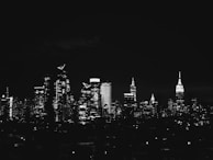 A nighttime shot of a city skyline featuring multiple buildings designed by Avani Structural Engineering, illuminated and robust.